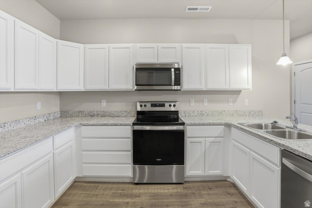 1838 West 300th Street South, Unit B Mapleton, UT 84664 - Photo 10 of 51 Kitchen featuring white shaker-style cabinetry, light speckled countertops, stainless steel appliances including a range, microwave, and dishwasher, and wood-finish flooring