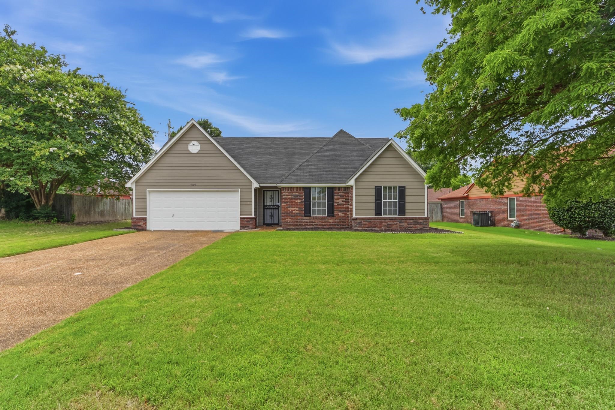 4101 Long Creek Road Memphis, TN 38125 - Photo 36 of 36 Front exterior featuring brick and siding facade, an attached garage, a paved driveway, and a spacious green lawn