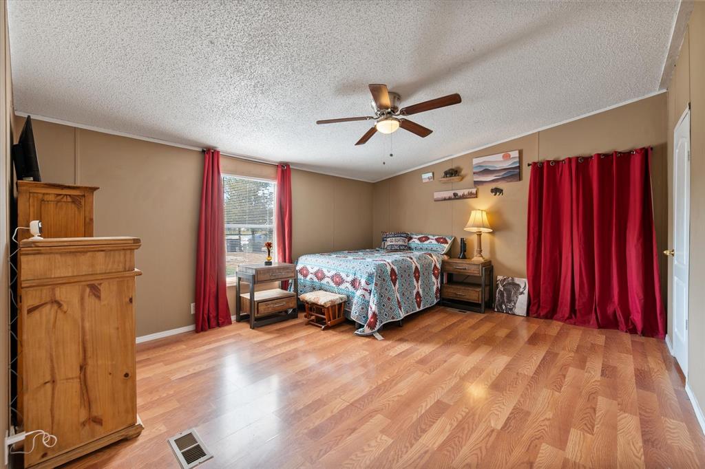 309 Southeast County Road Corsicana, TX 75109 - Photo 18 of 27 Expansive room featuring wood-finish flooring, a ceiling fan with integrated lighting, and a window with natural light
