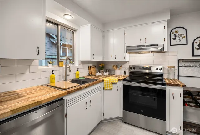 a kitchen with granite countertop a stove sink and cabinets