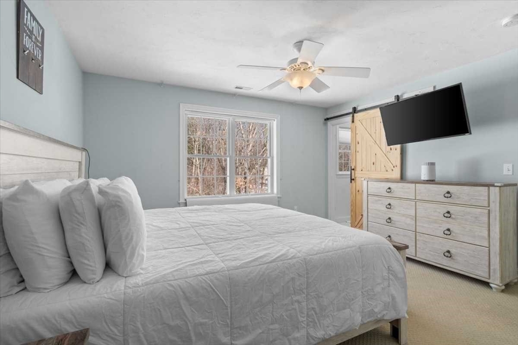 57 Partridge Hill Road Sutton, MA 01590 - Photo 16 of 40 a spacious bedroom with a large bed and a flat screen tv