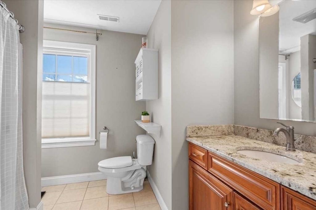 57 Partridge Hill Road Sutton, MA 01590 - Photo 24 of 40 a bathroom with a granite countertop sink a toilet and a window
