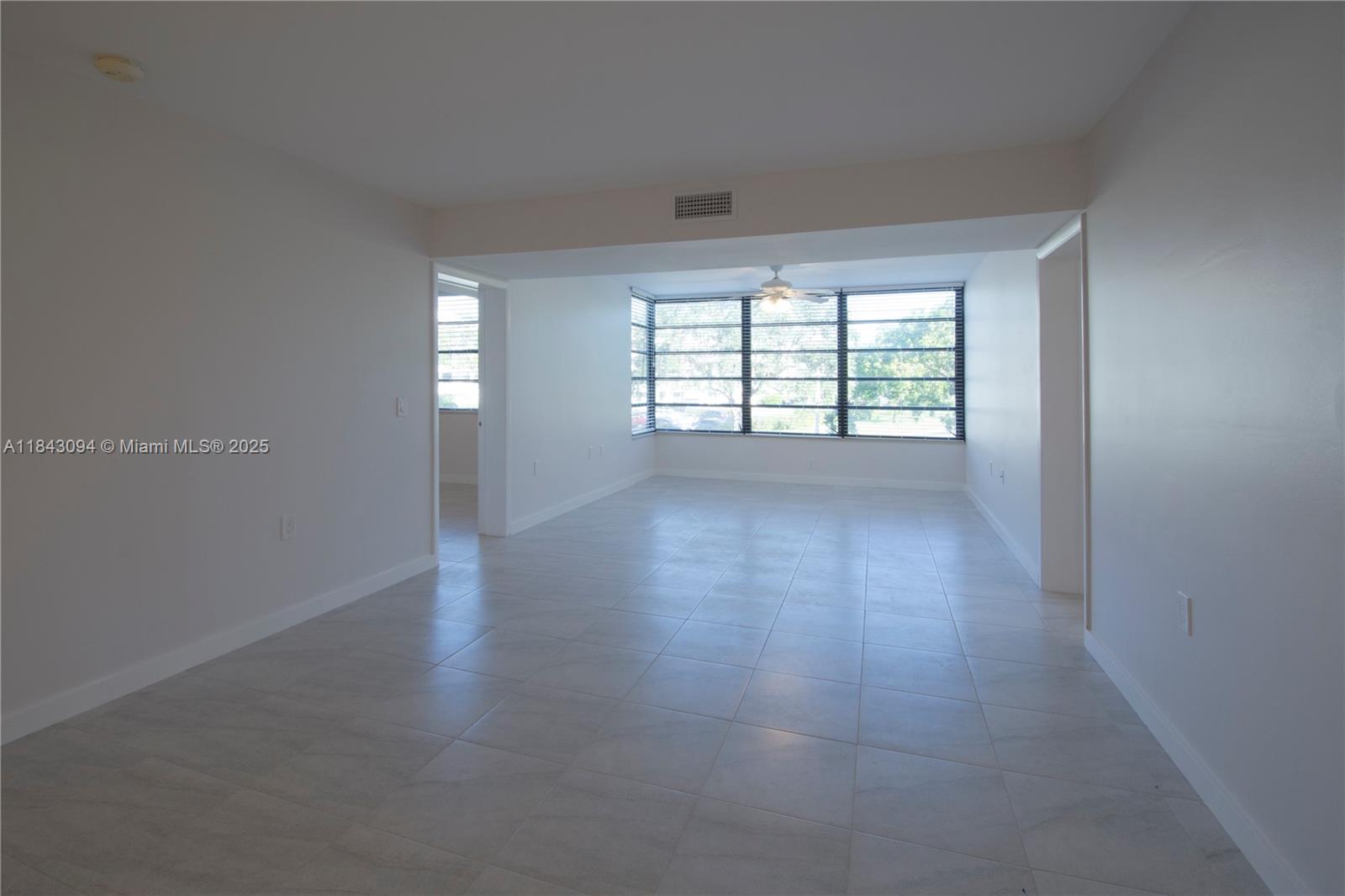 1717 Whitehall Drive, Unit 201 Davie, FL 33324 - Photo 3 of 18 an empty room with wooden floor and windows