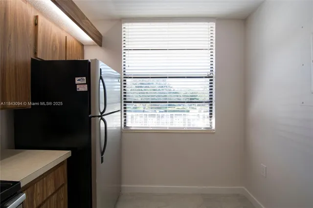 a kitchen with stainless steel appliances a refrigerator and a window