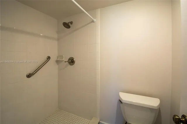 a white toilet sitting next to a shower