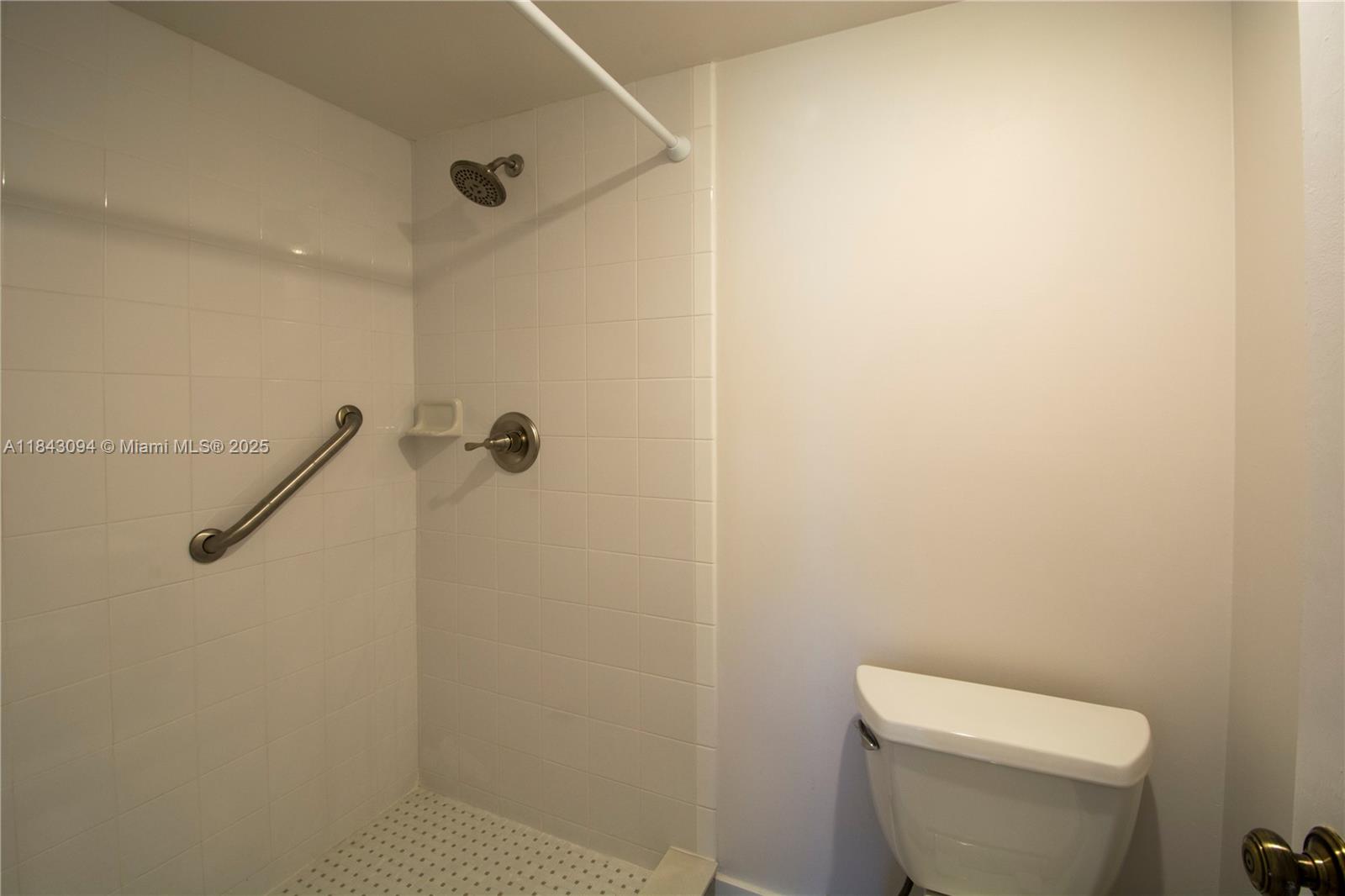 1717 Whitehall Drive, Unit 201 Davie, FL 33324 - Photo 9 of 18 a white toilet sitting next to a shower