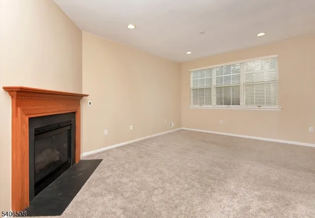 a view of an empty room with a fireplace and a window