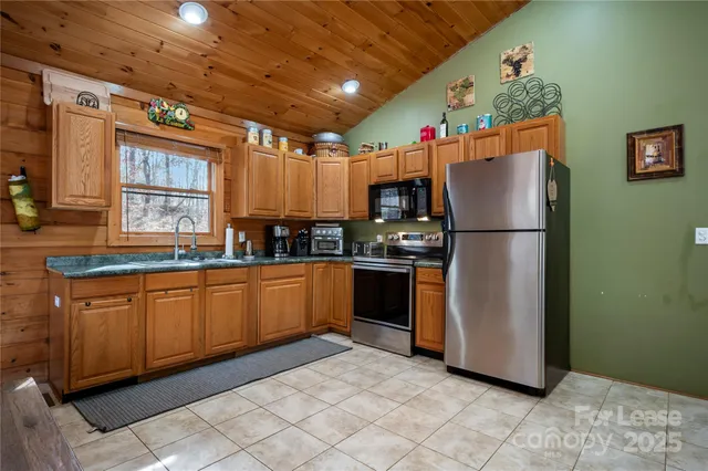 a kitchen with granite countertop a refrigerator and a sink