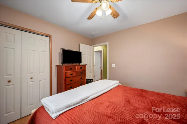 a bedroom with a bed and a flat tv screen on wall