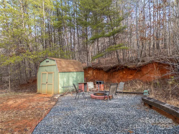 a backyard of a house with barbeque oven table and chairs