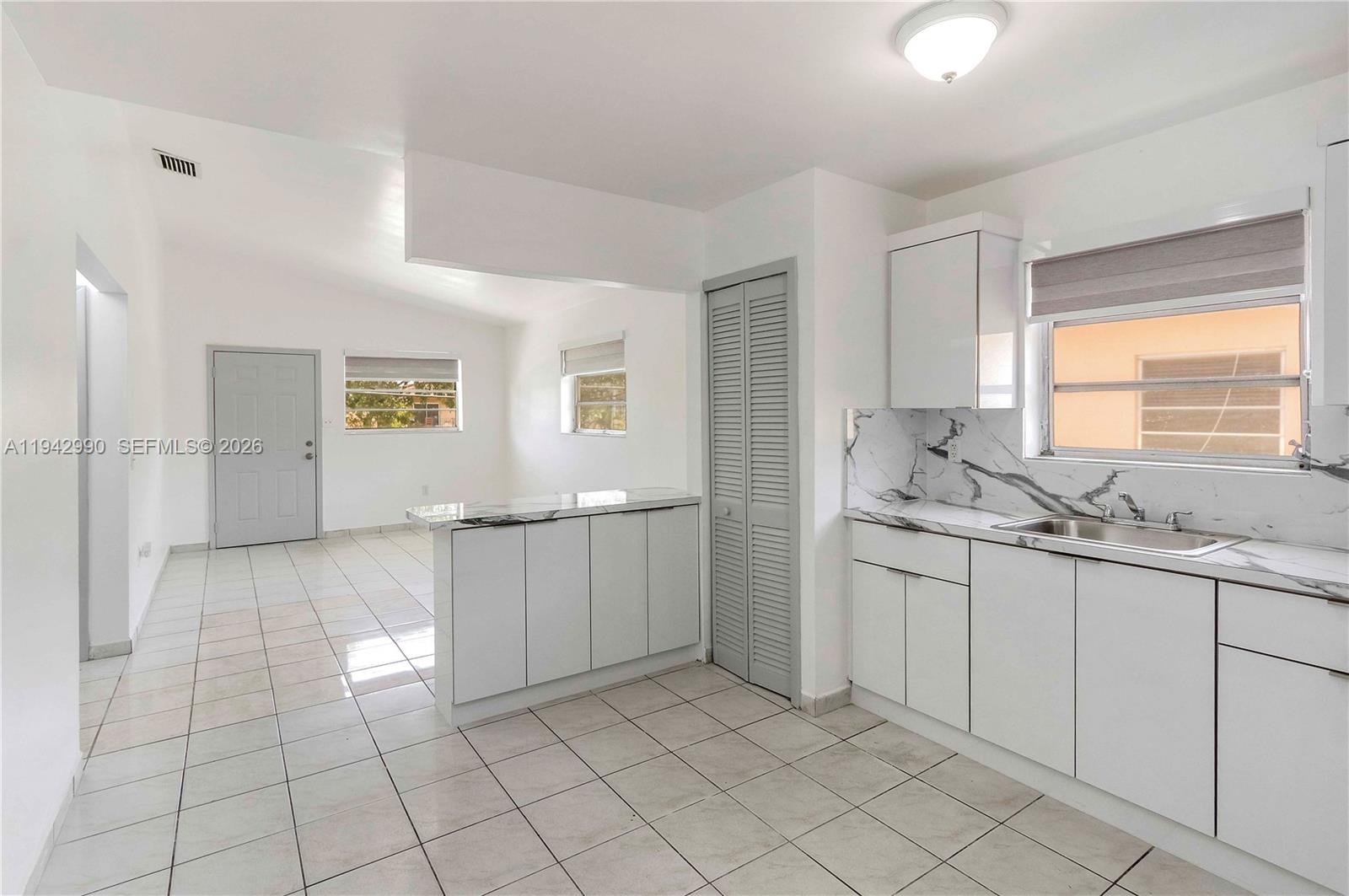 642 East 2nd Avenue, Unit A Hialeah, FL 33010 - Photo 3 of 14 a bathroom with a sink a toilet and large mirror