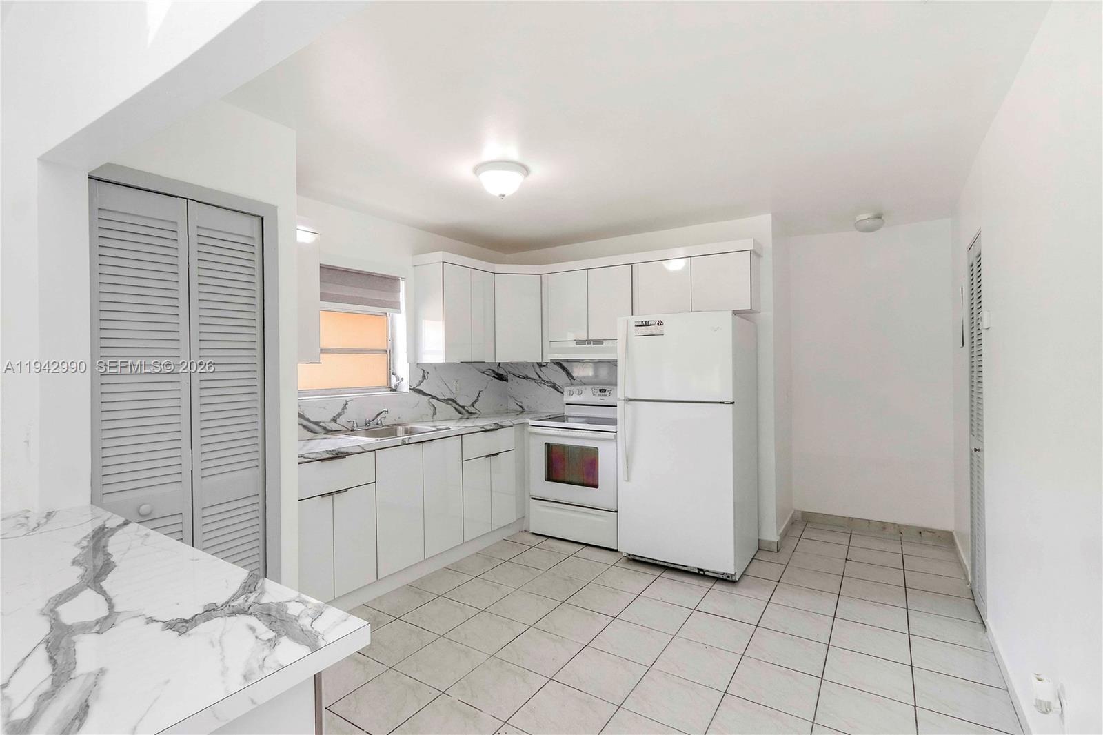 642 East 2nd Avenue, Unit A Hialeah, FL 33010 - Photo 5 of 14 a kitchen with white cabinets and white appliances