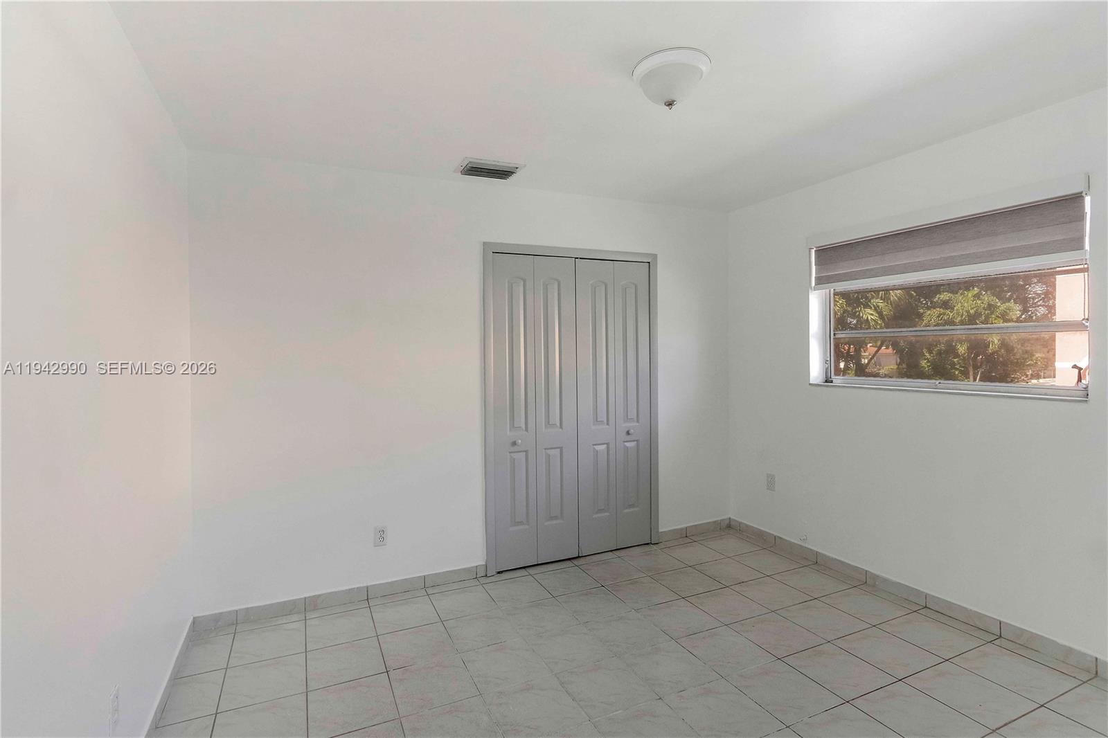 642 East 2nd Avenue, Unit A Hialeah, FL 33010 - Photo 9 of 14 an empty room with windows