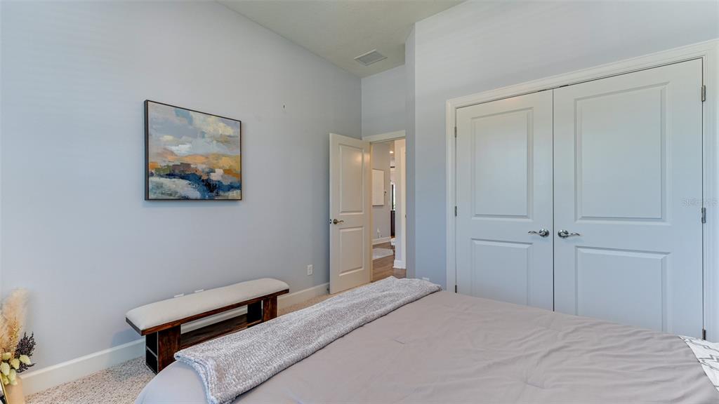 4511 Terrazza Court Lakewood Ranch, FL 34211 - Photo 23 of 65 a bedroom with a bed and a wall painting