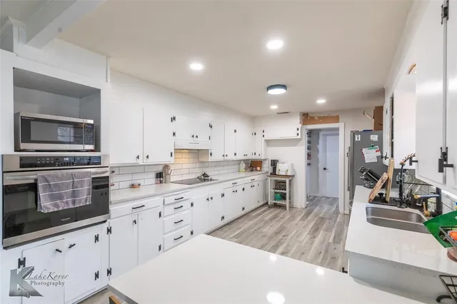 a kitchen with lots of counter top space and wooden floor