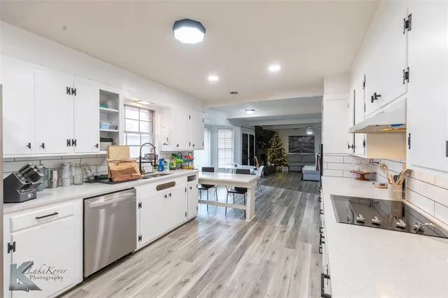 a kitchen with white cabinets and sink