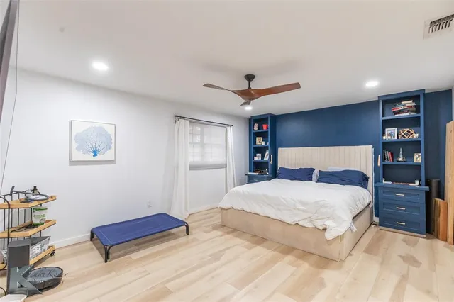 a bedroom with a large bed and a chandelier