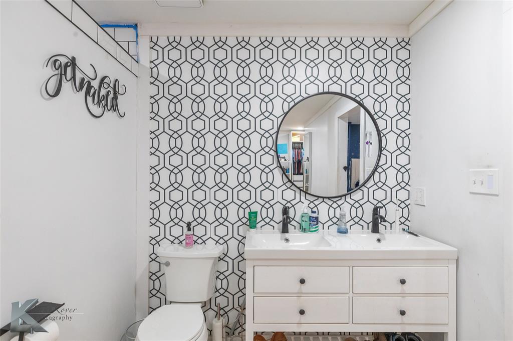 1909 River Oaks Road Abilene, TX 79605 - Photo 21 of 40 a bathroom with a toilet sink and mirror