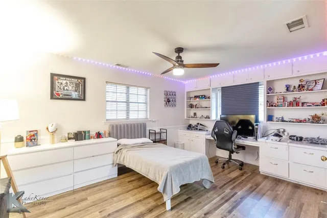 a bedroom that has a bed and a bookshelf with wooden floor