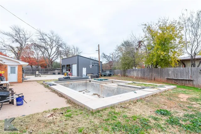a view of a house with a yard and a large tree