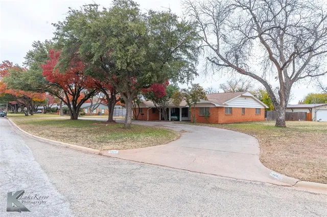 a view of house with outdoor space and trees