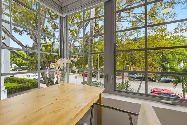 a view of a living room with a floor to ceiling window and wooden floor