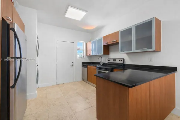 a kitchen with granite countertop a sink stove and refrigerator