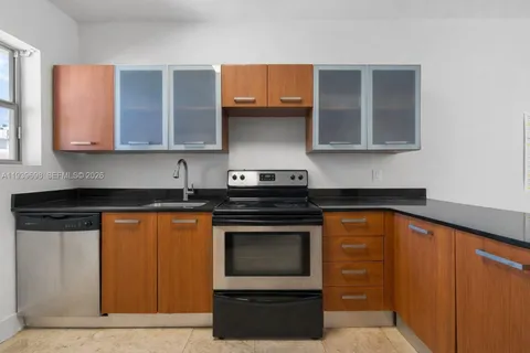 a kitchen with granite countertop wood cabinets and stainless steel appliances