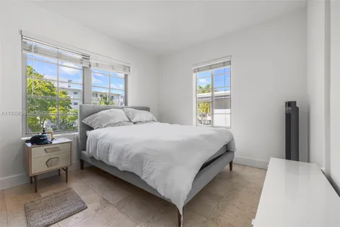 a bedroom with a bed and large windows