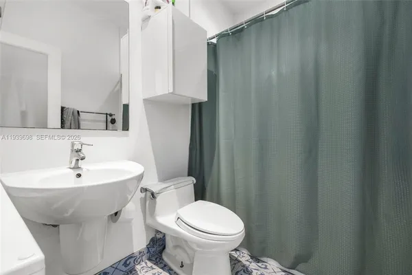 a bathroom with a sink toilet and a mirror