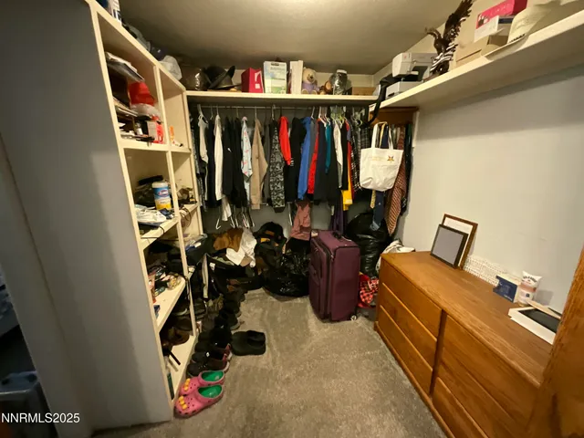 a view of walk in closet with clothes and shoes