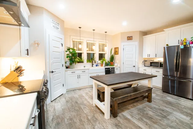 a kitchen with stainless steel appliances a stove a sink and a refrigerator