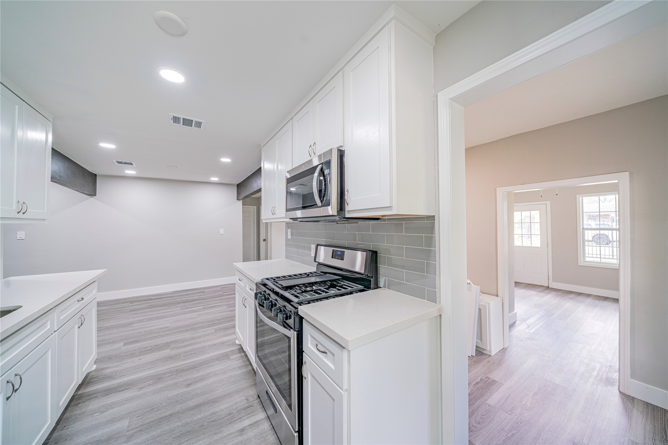 5718 Cherry Street Houston, TX 77026 - Photo 16 of 35 a kitchen that has a lot of cabinets a sink and wooden floor