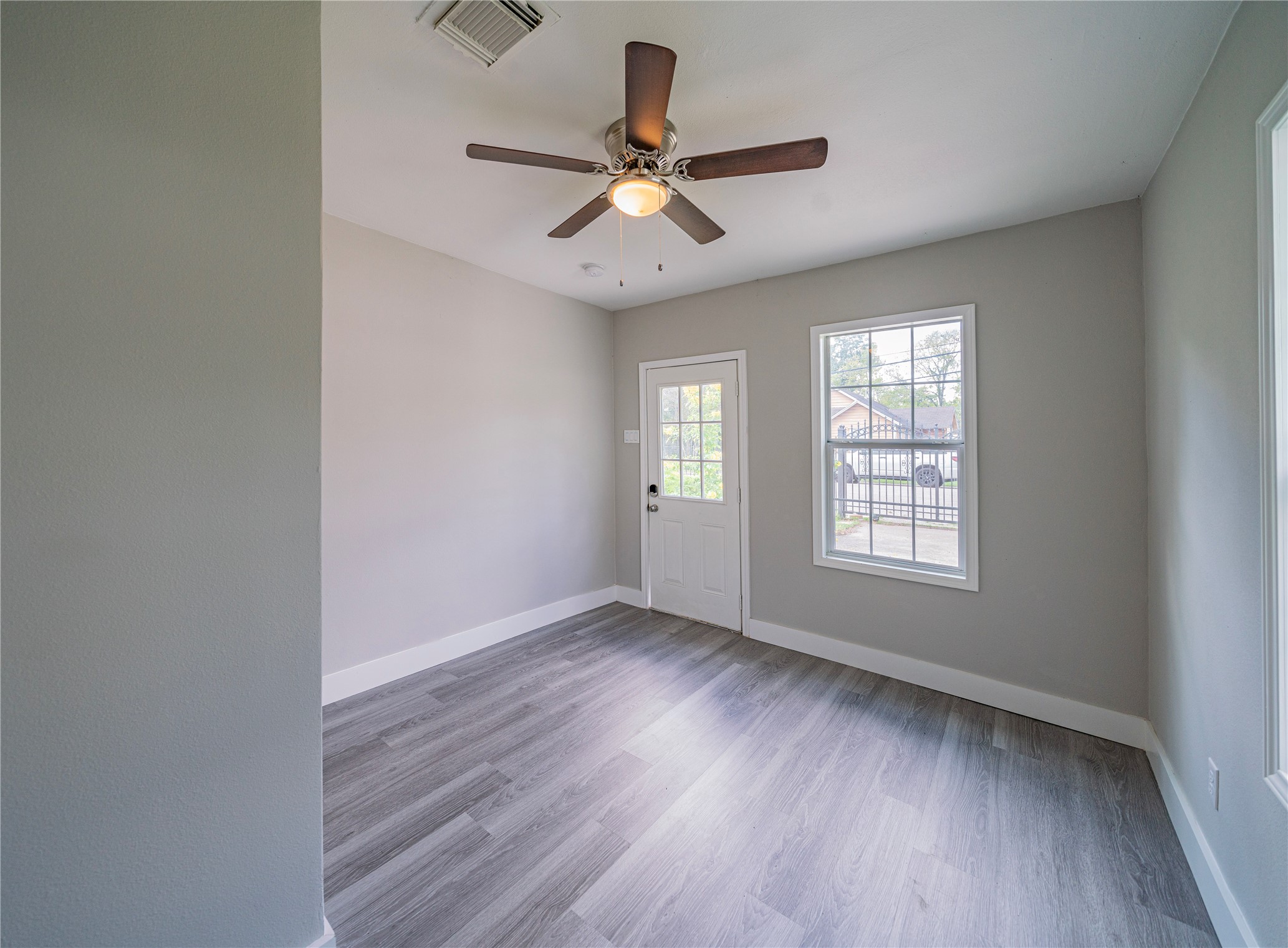 5718 Cherry Street Houston, TX 77026 - Photo 22 of 35 an empty room with wooden floor window and ceiling fan