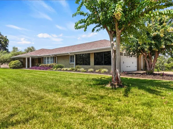 a view of house with yard and outdoor seating