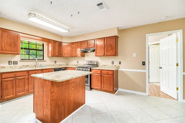 a kitchen with stainless steel appliances granite countertop a stove sink and cabinets