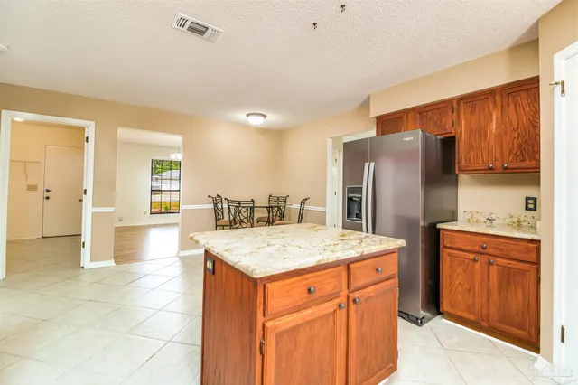 a kitchen with stainless steel appliances granite countertop a refrigerator and a stove top oven