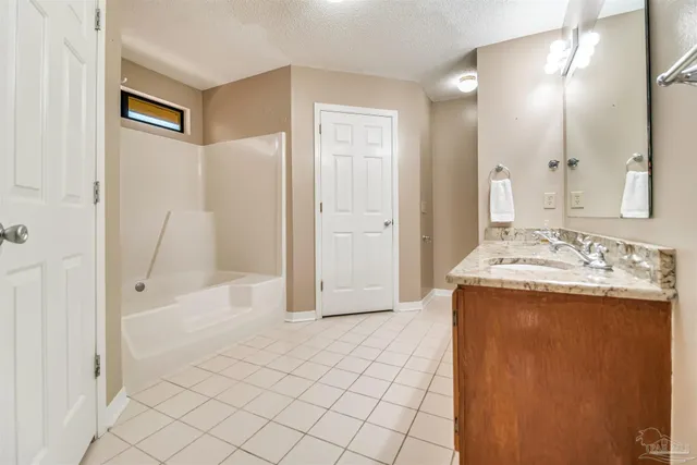 a bathroom with a granite countertop sink a mirror and a shower