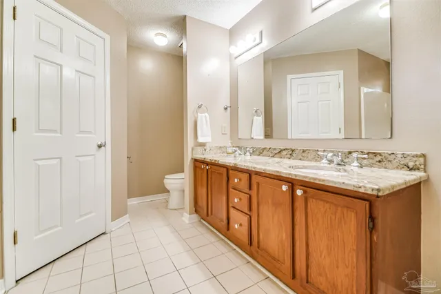 a spacious bathroom with a granite countertop sink and a mirror