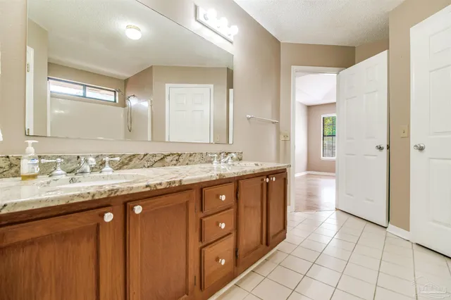 a spacious bathroom with a granite countertop sink and a mirror