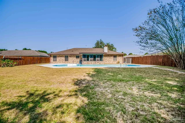 a front view of house with yard and swimming pool