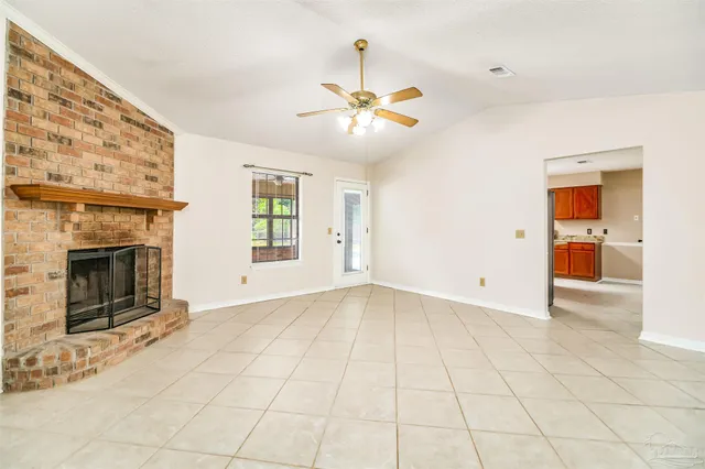 an empty room with windows and fireplace