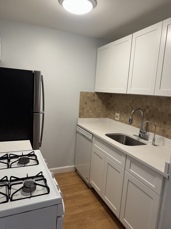 144 Kenrick Street, Unit 37 Boston, MA 02135 - Photo 2 of 12 a utility room with sink dryer and washer