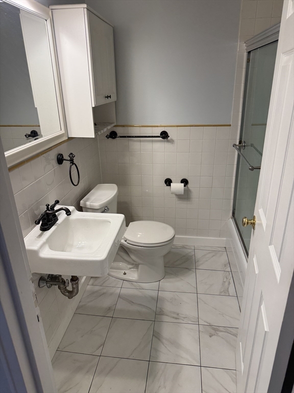 144 Kenrick Street, Unit 37 Boston, MA 02135 - Photo 5 of 12 a bathroom with a sink a toilet and a mirror