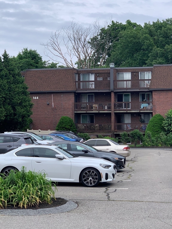 144 Kenrick Street, Unit 37 Boston, MA 02135 - Photo 7 of 12 a car parked in front of a house