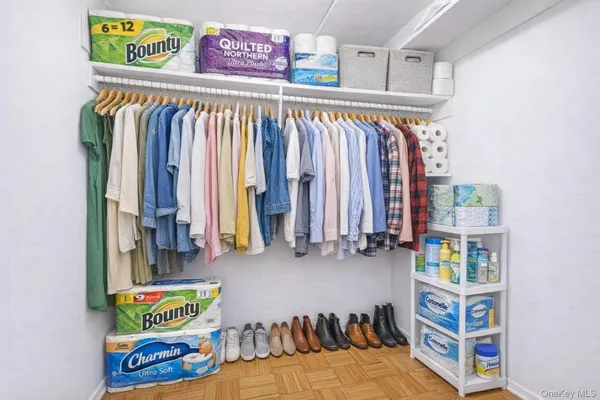 a view of walk in closet with clothes and shoes