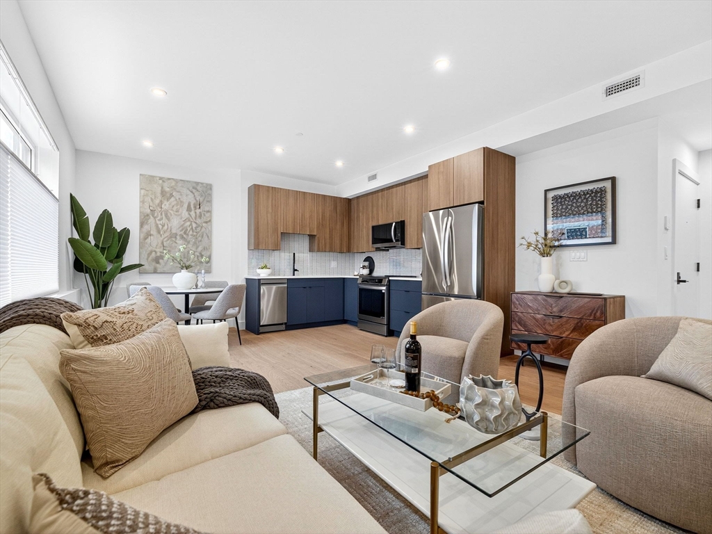 a living room with furniture kitchen view and a refrigerator