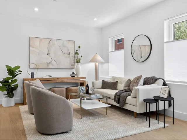 a living room with furniture a table and a potted plant