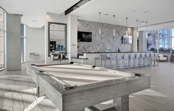 a living room with stainless steel appliances furniture a window and a kitchen view
