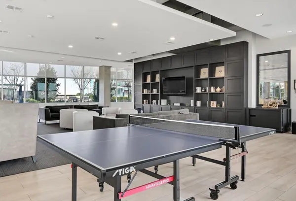 a large white kitchen with a sink and living area view